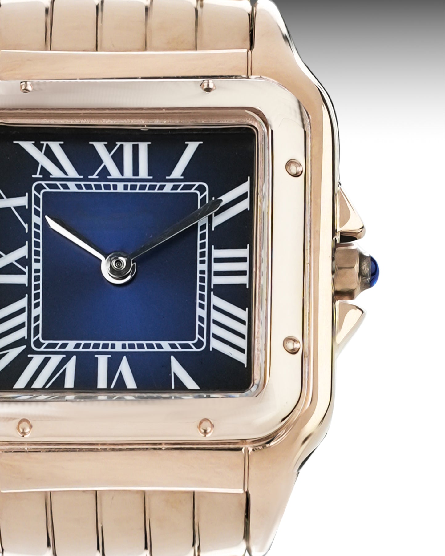 Rose gold watch with blue face and Roman numerals on a gray background