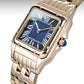 Rose gold watch with blue face and gemstone on a white background