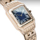 Rose gold watch with a blue face on a gray background